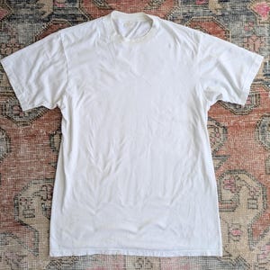 May include: A plain white t-shirt with a crew neck.