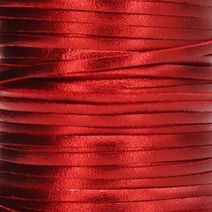 May include: A spool of red leather cord, wound tightly and ready for crafting projects.