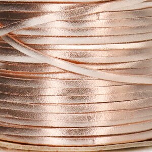 May include: A spool of rose gold leather cord. The cord is wound tightly around the spool and is ready to be used for crafting projects.