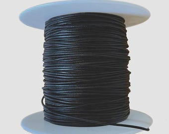 May include: A spool of black leather cord, wound around a white plastic spool.