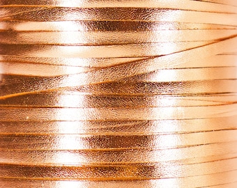 May include: Close-up of a spool of metallic gold leather cord. The cord is wound tightly and has a shiny, reflective surface.