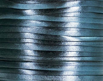 Puede incluir: Primer plano de un carrete de cordón de cuero azul turquesa. El cordón está hecho de tiras finas de cuero que están entrelazadas.