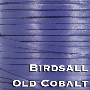 Könnte beinhalten: Eine Spule mit flachem, kobaltblauem Lederband, das in engen, horizontalen Reihen gewickelt ist. Der Text "BIRDSALL" erscheint in weißen Großbuchstaben über dem Text "OLD COBALT" in weißen Großbuchstaben am unteren Bildrand.