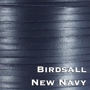 May include: A spool of dark navy blue leather cord with a textured surface. The leather strips are wound tightly together in parallel rows. The text BIRDSALL NEW NAVY is printed in white capital letters across the lower portion of the image.
