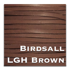 Könnte beinhalten: Nahaufnahme eines braunen Lederbandes, das die Textur des Leders zeigt. Der Text "BIRDASALL LGH BROWN" ist auf das Band gedruckt.