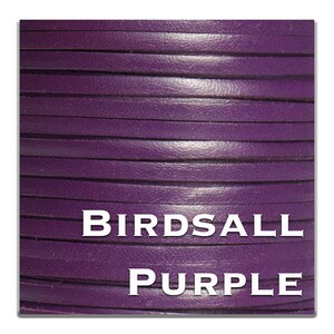 May include: Close-up of a roll of purple leather cord. The cord is smooth and has a slight sheen. The text "BIRDASLL PURPLE" is printed on the cord.