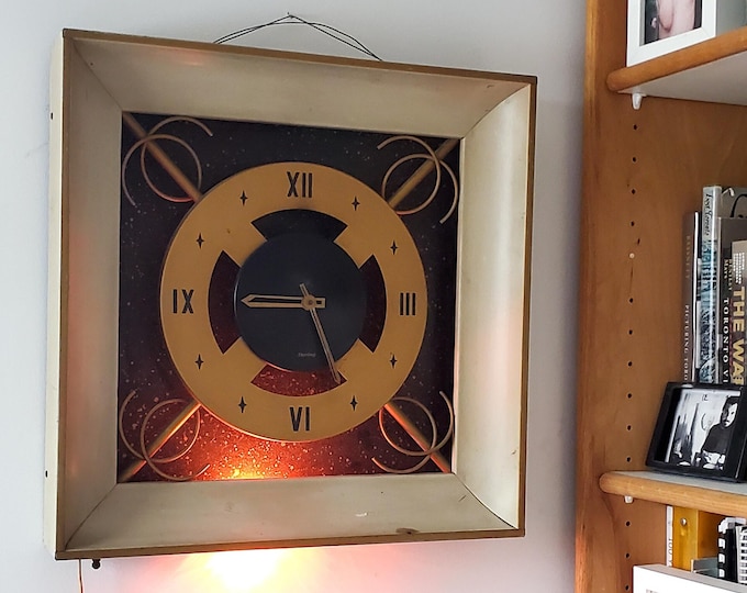 1960's Sterling Electrical Wall Clock with Art deco Styling and Bulb illumination.