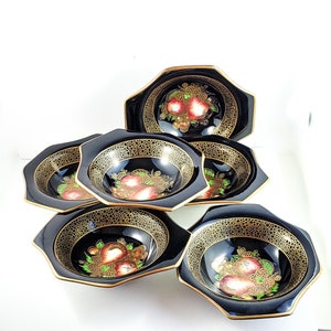 Puede incluir: Juego de seis cuencos octogonales negros y dorados con un diseño de frutas. Los cuencos están hechos de cerámica y tienen un acabado brillante.