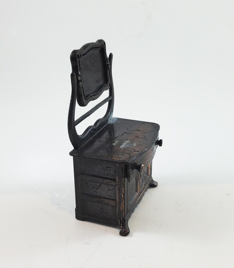 May include: A black metal vanity with a mirror and a drawer. The vanity is a vintage pencil sharpener.