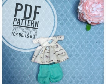 Puede incluir: Patrón de costura PDF para vestidos y bragas para muñecas de 16 cm. El patrón incluye un vestido blanco con estampado de taza de té y flores y unos pantalones cortos verde azulado.