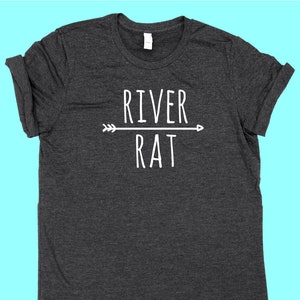 May include: A dark gray t-shirt with a white graphic design that says "River Rat" with an arrow pointing to the right.