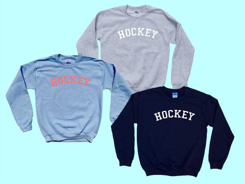 Pu&ograve; includere: Tre felpe con la parola "HOCKEY" stampata sul davanti. Una felpa &egrave; azzurra con la parola in rosa, una &egrave; grigia con la parola in bianco e l'ultima &egrave; blu scuro con la parola in bianco.