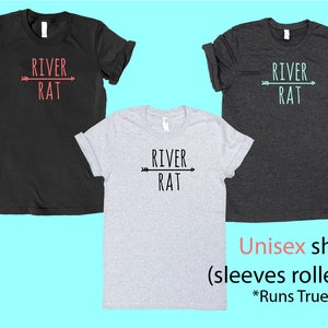 May include: Three unisex t-shirts with the text "River Rat" and an arrow graphic. The shirts are in black, heather grey, and dark heather grey. The text is in black and red.