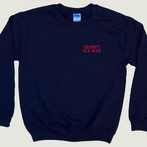 May include: A navy blue sweatshirt with the text "GRUMPY OLD MAN" embroidered in red on the front.