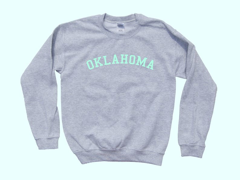 May include: A gray sweatshirt with the word "OKLAHOMA" printed in light green on the front.