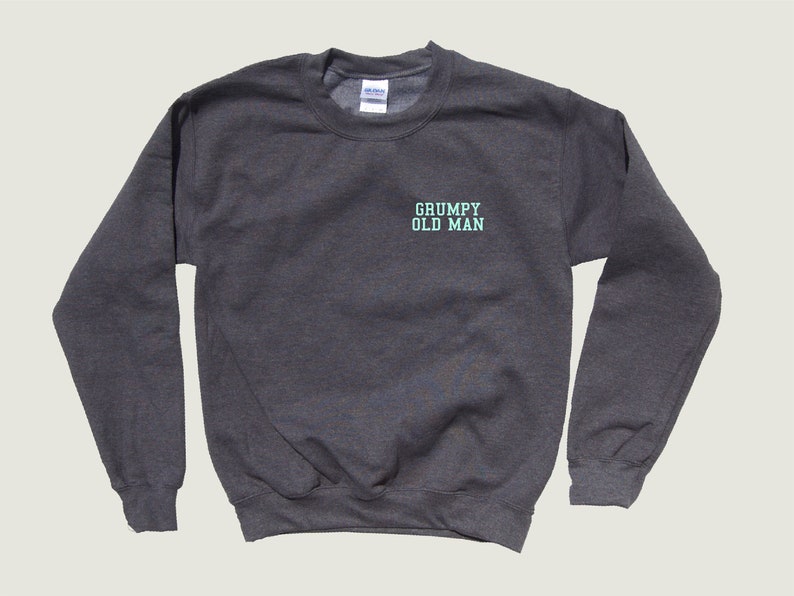 May include: A dark gray sweatshirt with the text "GRUMPY OLD MAN" in light blue on the front.