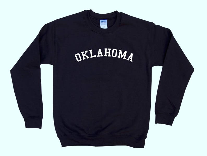 May include: Black long-sleeved sweatshirt with white text that reads "OKLAHOMA" across the chest.