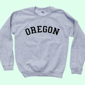 May include: A gray sweatshirt with the word "OREGON" printed in black on the front.