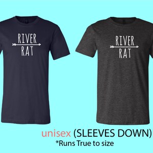 May include: Two t-shirts, one navy blue and one dark heather grey, with a white graphic of an arrow pointing to the right with the text "RIVER RAT" underneath. The t-shirts are unisex and have sleeves that are down. The text "unisex (SLEEVES DOWN)" and "*Runs True to size" are printed below the t-shirts.