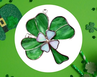 Peut inclure: Un trèfle en verre teinté vert avec un centre blanc. Le trèfle est un symbole populaire de la culture irlandaise et est souvent utilisé comme décoration pour la Saint-Patrick.