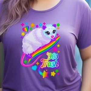 May include: A purple t-shirt with a graphic of a cartoon possum riding a rainbow with the text "90s Trash".