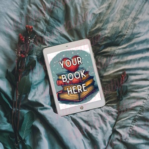 K&ouml;nnte beinhalten: Ein wei&szlig;es Tablet mit blauem Hintergrund und einem roten Herzen mit dem Text "YOUR BOOK HERE" auf dem Bildschirm. Das Tablet liegt auf einem blauen und wei&szlig;en Bettbezug mit gr&uuml;nen Bl&auml;ttern und roten Blumen.