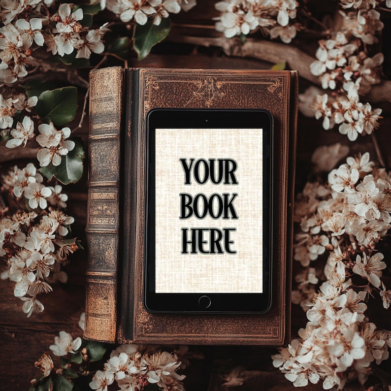 Może przedstawiać: Antyczna książka z tabletem na g&oacute;rze. Ekran tabletu wyświetla tekst "YOUR BOOK HERE" czarnym kolorem na białym tle. Książka i tablet są otoczone białymi kwiatami.