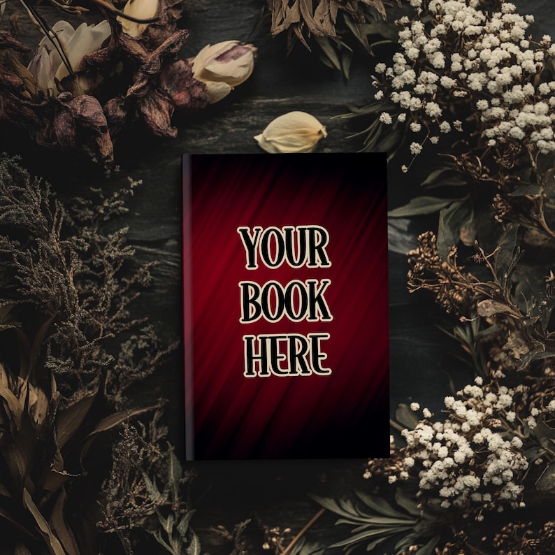 Może przedstawiać: Okładka książki w ciemnym kolorze czerwonym z tekstem "YOUR BOOK HERE" w złotych literach. Książka jest otoczona suszonymi kwiatami i liśćmi.