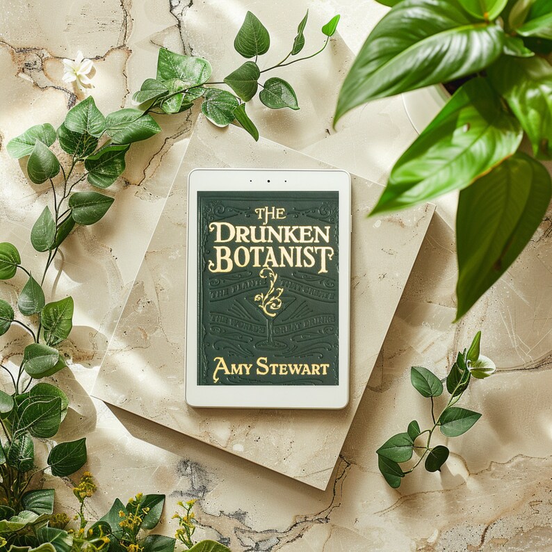 May include: A green book with the title "The Drunken Botanist" by Amy Stewart. The book is on a light brown surface with green plants around it.