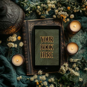 Może przedstawiać: Brązowy, sk&oacute;rzany dziennik w ciemnym odcieniu z czarnym ekranem tabletu, na kt&oacute;rym wyświetla się tekst "YOUR BOOK HERE" na zielonym tle. Dziennik otoczony jest świecami i zielenią.