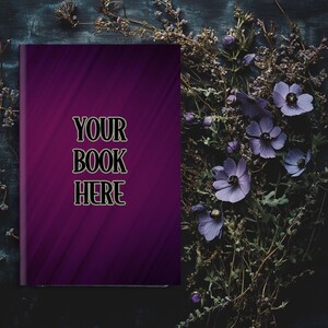 Może przedstawiać: Fioletowa okładka książki z tekstem "YOUR BOOK HERE" na ciemnym drewnianym tle z fioletowymi kwiatami.