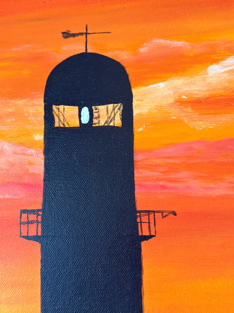 May include: A black silhouette of a tall tower with a cross on top against a bright orange and pink sunset sky. The tower has two windows and a small balcony.