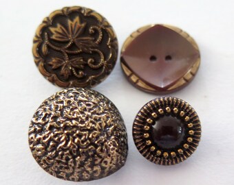 May include: Four decorative buttons in various styles. One button features a floral design with gold accents, another has a textured surface, and two have a dark brown color with gold accents.