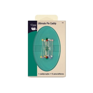Puede incluir: Un porta agujas de plástico verde con 15 agujas de colores. El porta agujas es de forma ovalada y tiene una tapa de plástico transparente. El embalaje es blanco con detalles verdes y dice "Ultimate Pin Caddy" y "Dritz".