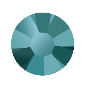 Puede incluir: Un brillante redondo de color azul verdoso con un diseño facetado.