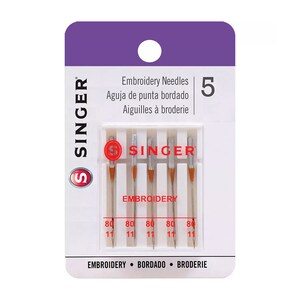 May include: A package of 5 Singer embroidery needles, size 80/11, with the brand name and "Embroidery" printed on the front. The package is purple and white with the text "Embroidery Needles, Aguja de punta bordado, Aiguilles à broderie" printed in black.