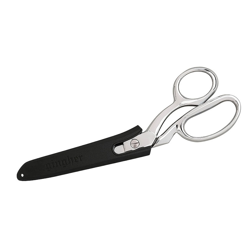 Pode incluir: Um par de tesouras de tecido prateadas com uma pega de borracha preta. A pega tem a palavra "Wrights" impressa.