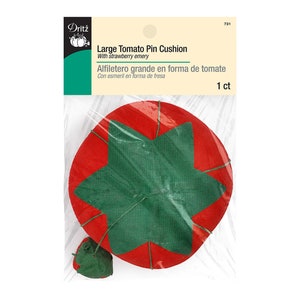 May include: A red tomato-shaped pin cushion with a green star in the center. The pin cushion is packaged in a clear plastic bag with a white label that reads "Large Tomato Pin Cushion with strawberry emery" and "Alfiletero grande en forma de tomate Con esmeril en forma de fresa 1 ct".