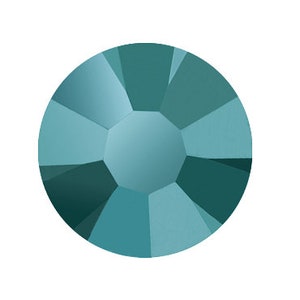 Puede incluir: Un brillante redondo de color azul verdoso con un diseño facetado.