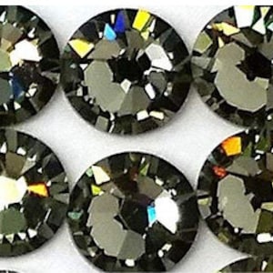 May include: Close-up of a group of dark gray rhinestones with iridescent facets.