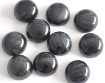 May include: Ten round, black gemstone cabochons with a subtle iridescent sheen. The cabochons are smooth and polished.