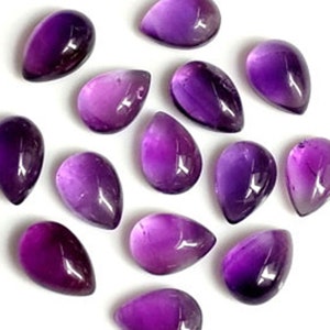 May include: A collection of 15 purple amethyst gemstone cabochons in a teardrop shape.