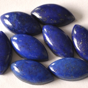 Könnte beinhalten: Neun polierte, oval geformte Lapislazuli-Edelsteine. Die Steine sind tiefblau mit goldenen Pyritflecken. Die Edelsteine sind glatt und haben einen leichten Glanz, ideal für Schmuckherstellung oder Sammlungen.