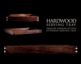 May include: Three wooden serving trays made of dark wood with a light wood trim. The trays are stacked on top of each other. The text "HARDWOOD SERVING TRAY" and "SMALLER VERSION OF OUR OTTOMAN SERVING TRAY" is displayed below the trays.