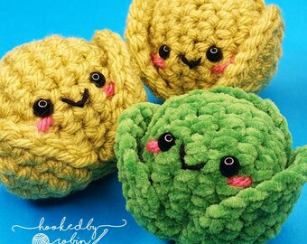 Puede incluir: Tres verduras de peluche tejidas a crochet, un brote de col verde y dos coles amarillas, con caras de dibujos animados lindas. Las coles tienen ojos negros, mejillas rosadas y una sonrisa negra. El brote de col tiene ojos negros, mejillas rosadas y una sonrisa negra.