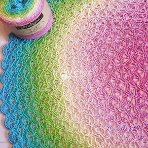May include: A colorful crochet mandala with a gradient of turquoise, green, yellow, and pink. The yarn ball is labeled "Scheepjes Whirl" and is in the upper left corner of the image.