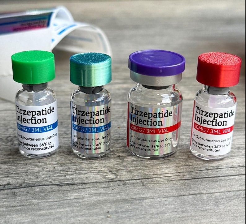 Four bottles of medication labeled "Tirzepatide Injection" are arranged on a wooden surface.