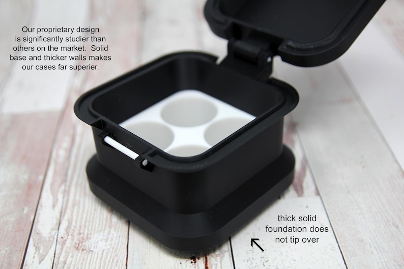 May include: Black square container with a hinged lid, featuring a white interior with four circular compartments. The text on the image says "Our proprietary design is significantly studier than others on the market. Solid base and thicker walls makes our cases far superior."