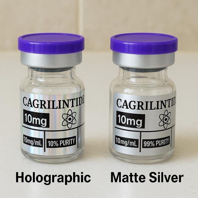 two identical glass vials with purple caps, labeled as "CAGRILINTIDE 10mg 10mg PURITY 10mg/ml 10%" and "CAGRILINTIDE 10mg 10mg PURITY 99% 10mg/ml 10%" respectively. The vials are labeled as "Holographic" and "Matte Silver" to differentiate between the two types of vials.