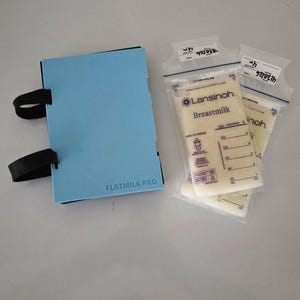 May include: A light blue FLATMILK PRO breastmilk storage case with black straps next to three Lansinoh Breastmilk bags. The bags are filled with breastmilk and have measurement markings.